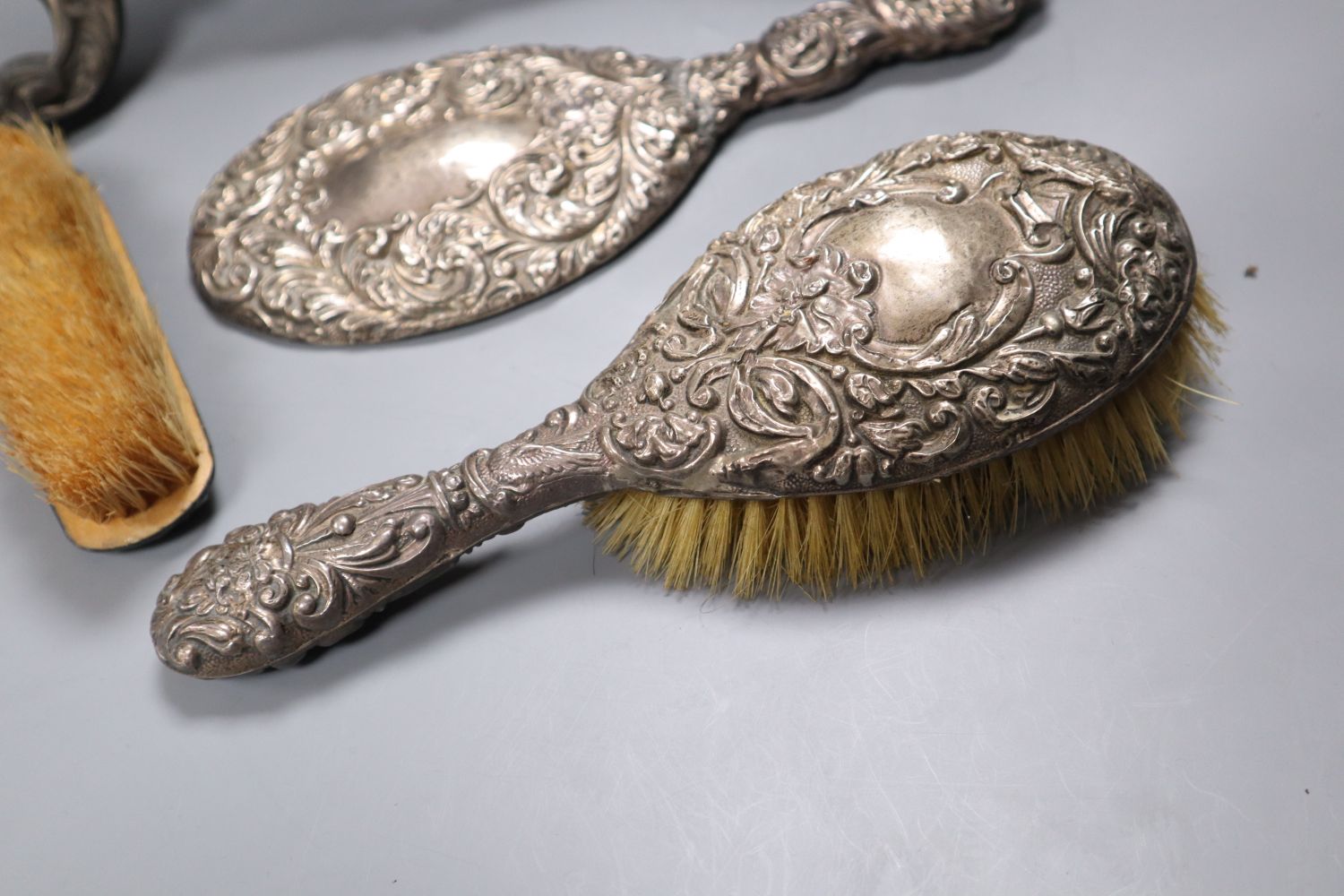 A Victorian cast metal easel mirror and a white metal mounted brush set